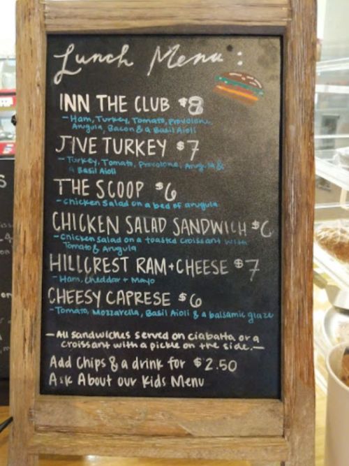Lunch menu on a chalkboard featuring items like Inn the Club, Jive Turkey, and Chicken Salad Sandwich with prices.