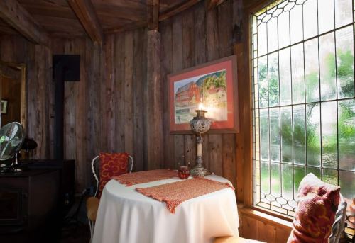 Cozy wooden interior with a small table, decorative lamp, and a stained glass window.