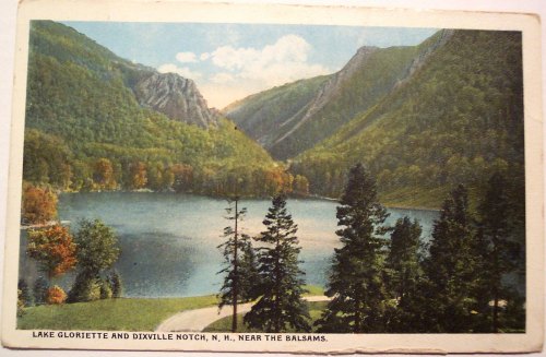 A scenic view of Lake Gloriette and Dixville Notch, surrounded by mountains and trees in autumn colors.