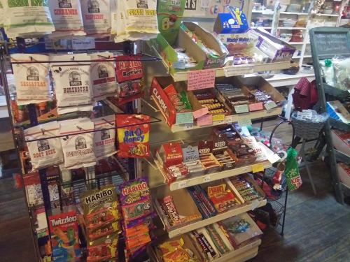 A colorful display of various candies and snacks on shelves in a store, including gummies, chocolates, and novelty treats.