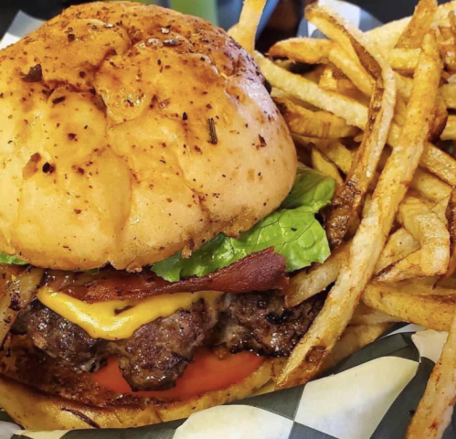 A juicy burger with cheese, lettuce, and tomato, served with crispy fries on the side.