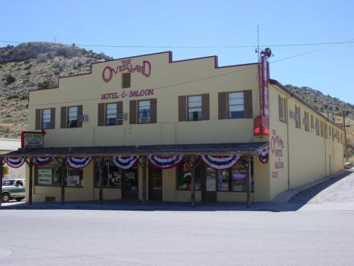 Historic yellow building with "The Overland Hotel & Saloon" sign, decorated with red, white, and blue bunting.