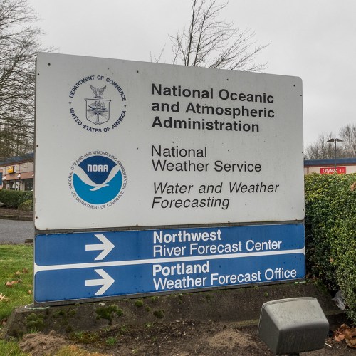 Sign for the National Oceanic and Atmospheric Administration, featuring weather services and forecast center directions.