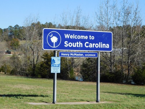 Welcome sign for South Carolina featuring a palm tree and crescent moon, with "Henry McMaster, Governor" below.