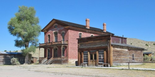 Historic buildings in a western-style ghost town under a clear blue sky.