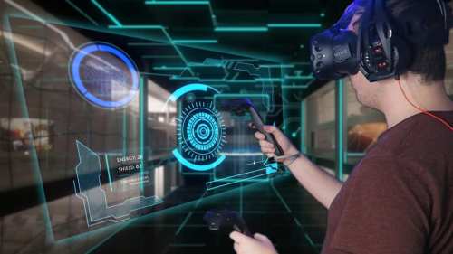 A person wearing a VR headset interacts with a holographic interface, holding controllers in a futuristic environment.