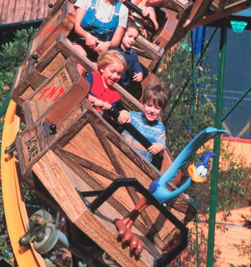 Children enjoying a fun amusement park ride, smiling and laughing as they experience the thrill together.
