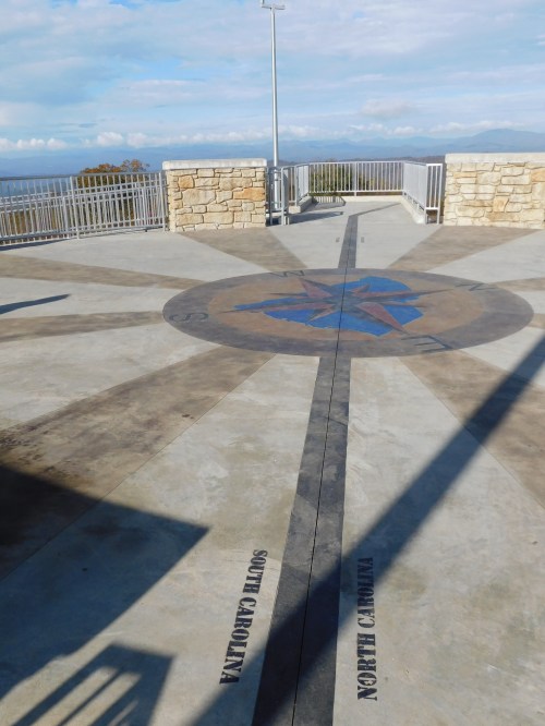 A compass rose design on a concrete surface, with directional labels for South Carolina and North Carolina.