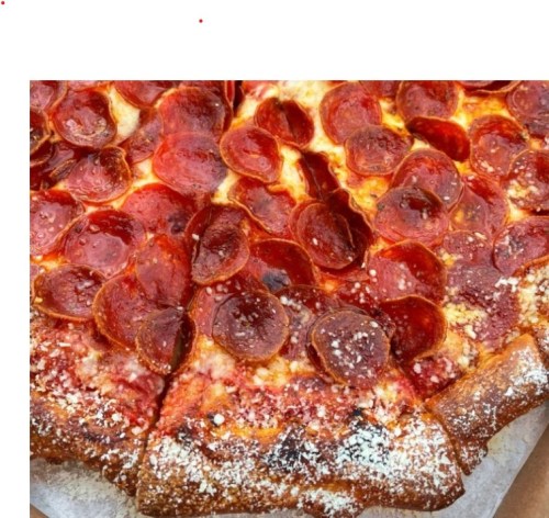 A close-up of a pepperoni pizza with a crispy crust and melted cheese, showcasing vibrant, slightly charred pepperoni slices.