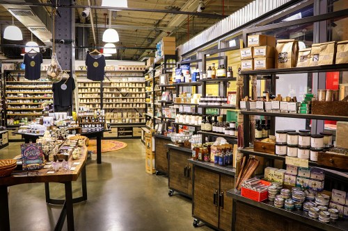 A cozy store interior filled with shelves of various products, including candles, soaps, and packaged goods.