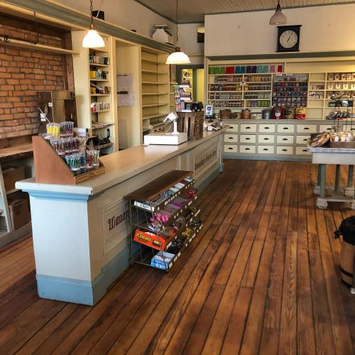 Interior of a vintage store with wooden counters, shelves filled with various items, and a warm, inviting atmosphere.