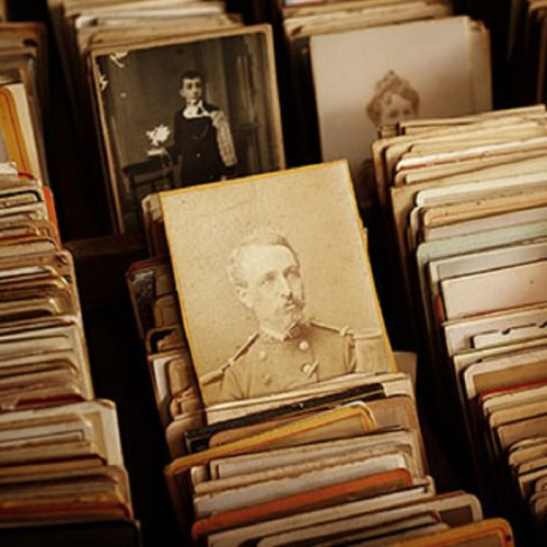 A collection of vintage photographs, with a prominent portrait of a man in military attire in the center.