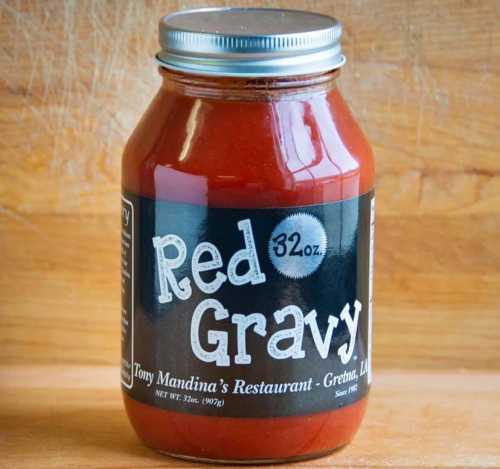 A jar of Red Gravy from Tony Mandina's Restaurant, 32 oz, with a black label on a wooden background.