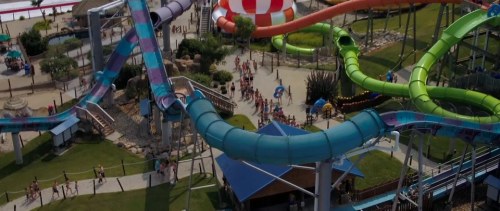 Aerial view of a water park featuring colorful slides and a busy area with people enjoying the attractions.