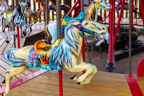 Colorful carousel horses on a vintage merry-go-round, featuring intricate designs and vibrant colors.