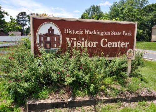 Sign for the Visitor Center at Historic Washington State Park, surrounded by greenery and blue skies.