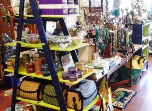 A colorful display of various items, including candles, bags, and accessories, in a vibrant shop setting.