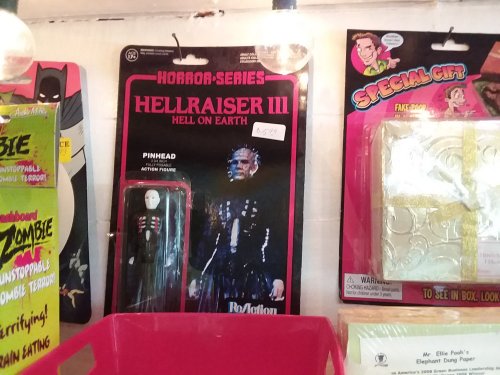 Action figure of Pinhead from "Hellraiser III" in packaging, displayed among other novelty items.