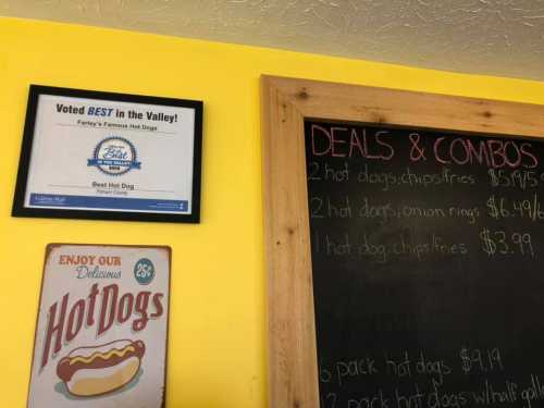 A sign on a yellow wall announces "Voted BEST in the Valley!" with hot dog deals and combos listed on a chalkboard.