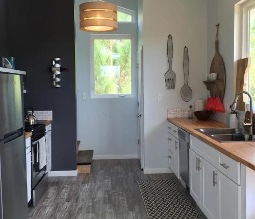 Modern kitchen with stainless steel appliances, wooden countertops, and a mix of light and dark walls. Bright and airy space.