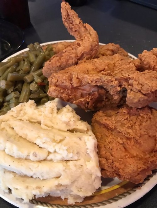 A plate of fried chicken, green beans, and creamy mashed potatoes.
