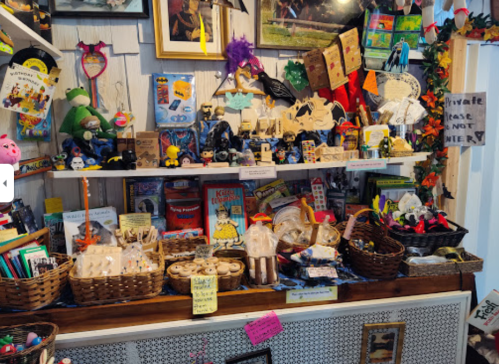 A colorful display of various toys, crafts, and souvenirs arranged on a wooden shelf with baskets and decorations.