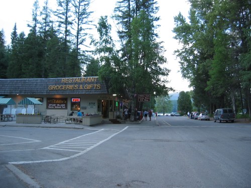A small roadside store with a restaurant and gift shop, surrounded by trees and parked cars in a quiet area.