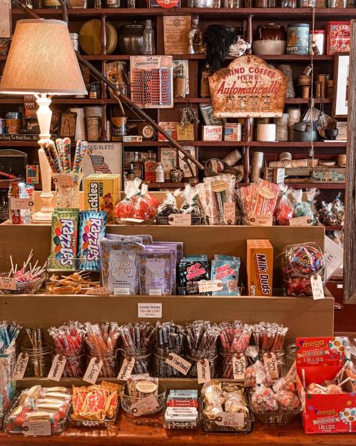 A colorful display of various candies and snacks in a vintage shop, with shelves filled with jars and nostalgic items.