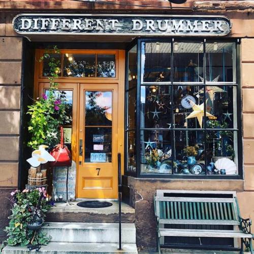 Charming storefront of "Different Drummer" with colorful decorations and a welcoming open sign.