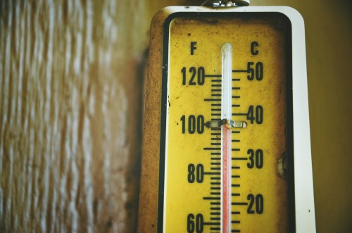 A close-up of a vintage thermometer showing temperatures in Fahrenheit and Celsius.