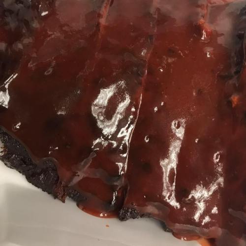 A close-up of a chocolate dessert with a glossy, dark chocolate glaze on top.