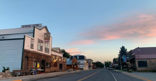 A quiet street scene at dusk featuring a general store and charming buildings under a colorful sky.