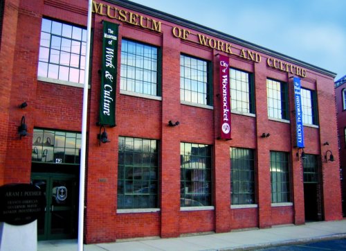 Exterior of the Museum of Work and Culture, featuring brick architecture and colorful banners.