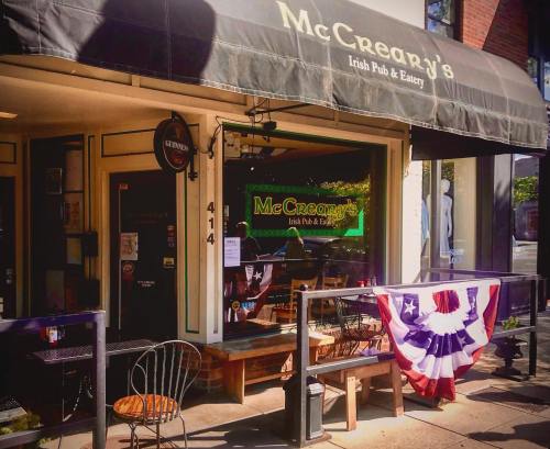 Exterior of McCreary's Irish Pub & Eatery, featuring a canopy and patriotic bunting on the railing.