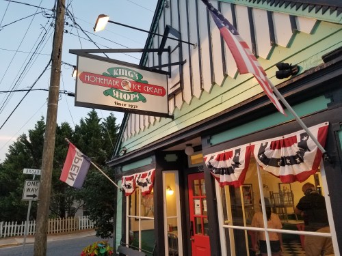 A quaint ice cream shop with a sign reading "King's Homemade Ice Cream" and patriotic decorations outside.