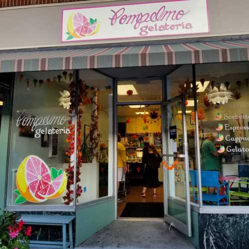 Exterior of a gelateria with a colorful sign and decorative fruit, showcasing a welcoming entrance and vibrant atmosphere.