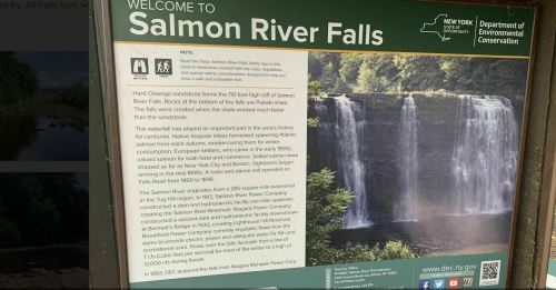 Sign welcoming visitors to Salmon River Falls, featuring information about the falls and conservation efforts.