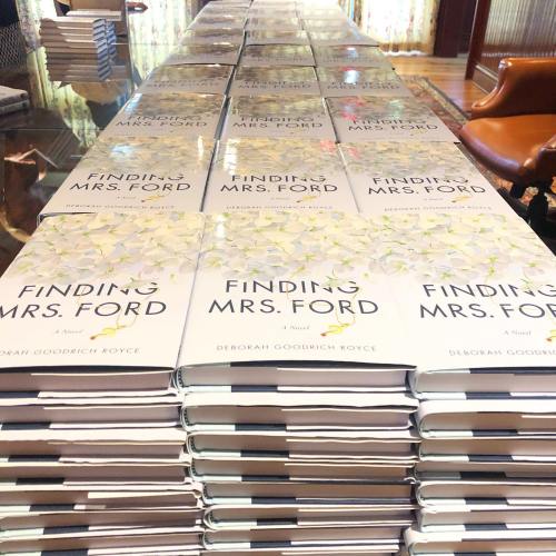 A table covered with multiple copies of the book "Finding Mrs. Ford" by Deborah Goodrich Royce.