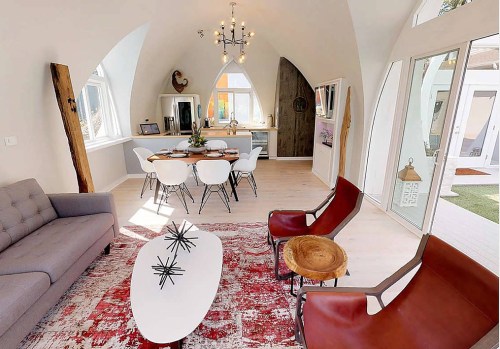 Bright, modern living space featuring a dining area, stylish furniture, and large windows for natural light.