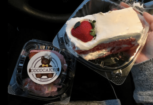 A hand holding two dessert containers: one with a slice of strawberry cake and another with a small cake labeled "CocoCakes."