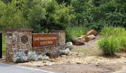 Sign for Chattahoochee Bend State Park, surrounded by greenery and rocks, welcoming visitors to the park.
