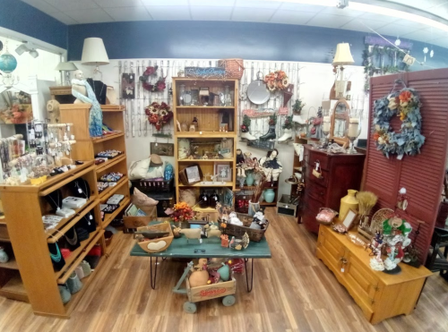 A cozy shop interior filled with wooden shelves, decor items, and seasonal decorations, creating a warm atmosphere.