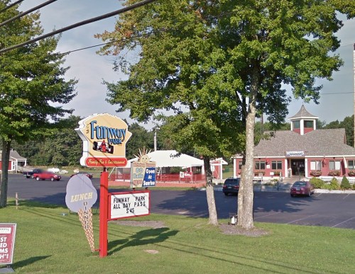 Sign for Funway Park with ice cream cone, grassy area, and a restaurant building in the background.