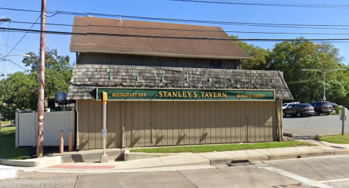 Exterior of Stanley's Tavern, a restaurant and bar, featuring a wooden facade and a shingled roof.