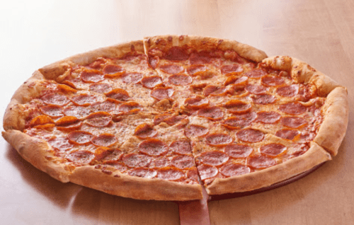 A large pepperoni pizza on a wooden surface, sliced into equal pieces.
