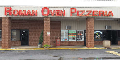 Exterior of Roman Oven Pizzeria with a red sign, open window, and brick facade.