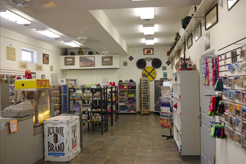 Interior of a gift shop featuring shelves of souvenirs, a popcorn machine, and various displays along the walls.