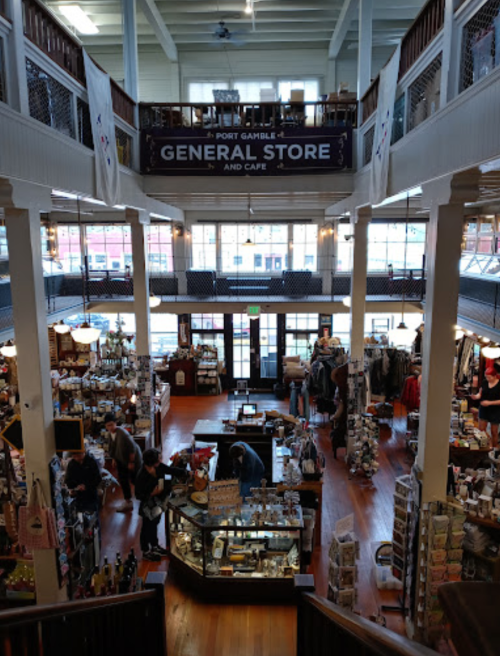 Interior of Port Gamble General Store and Cafe, featuring wooden floors, merchandise displays, and customers browsing.