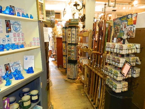 A cozy shop interior filled with various souvenirs, trinkets, and decorative items on shelves and displays.