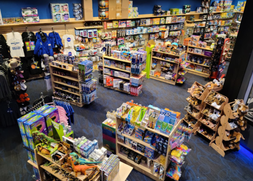 A colorful retail store filled with shelves of toys, games, and merchandise, arranged in an organized layout.